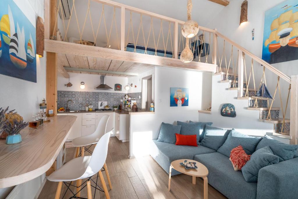 a living room with a blue couch and a kitchen at Libera Apartments in Stara Baška