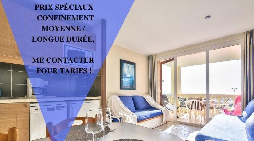 een woonkamer met een blauwe bank en een tafel bij Appartement l'Archipel - Vue mer exceptionnelle et bassins aquatiques du 29 avril au 15 sept in Talmont