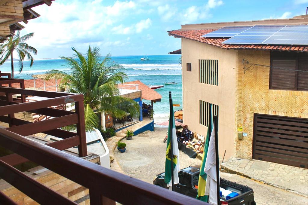 a balcony with a view of the ocean and a building at Pipa's Bay Apto 208 - Flat em Pipa RN in Pipa