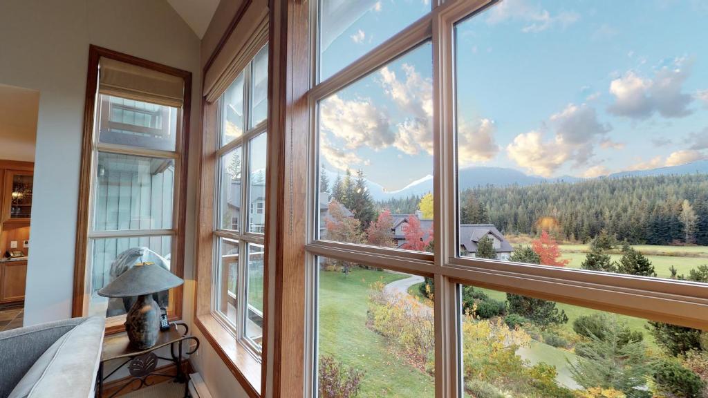 a room with a large window with a view at Golf Course & Mountain Views by Harmony Whistler in Whistler