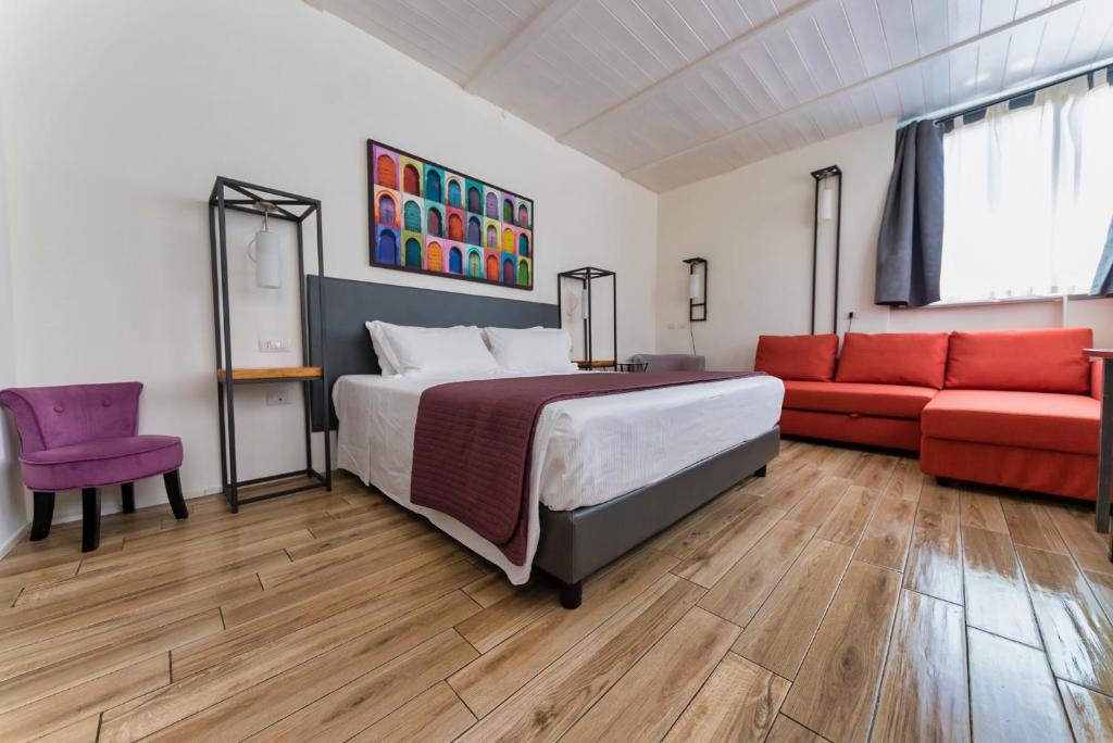um quarto com uma cama e um sofá vermelho em Hotel Casa Mia em Roma