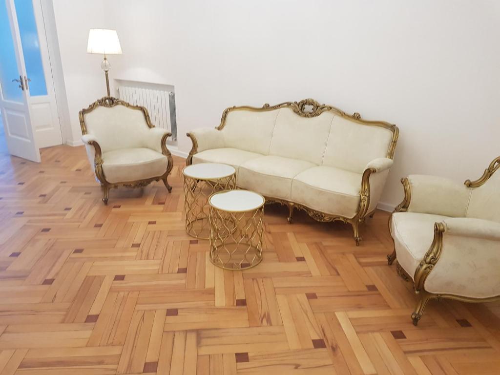 ein Wohnzimmer mit 2 Stühlen und einem Sofa in der Unterkunft Glamour apartment in Tbilisi City