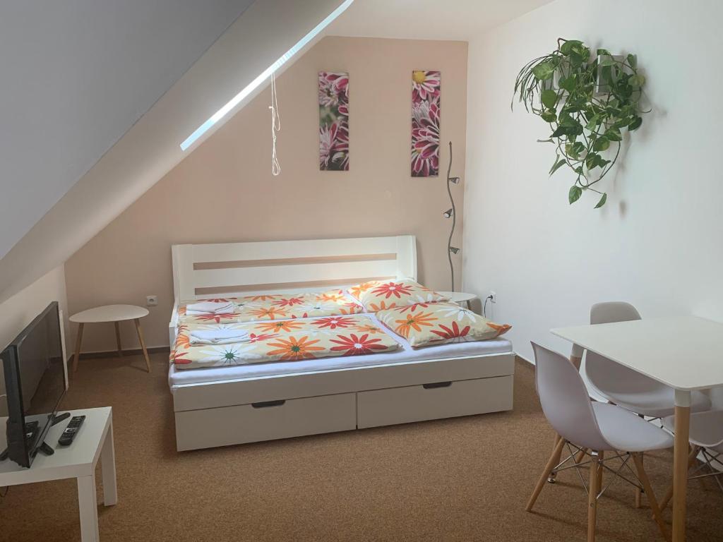 1 dormitorio con 1 cama, mesa y sillas en Penzion Karlov, en Karlov