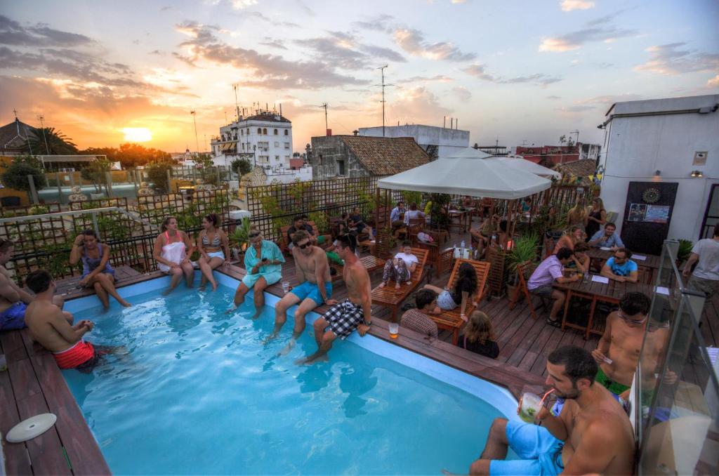 a group of people sitting in a swimming pool at Oasis Backpackers' Palace Seville in Seville
