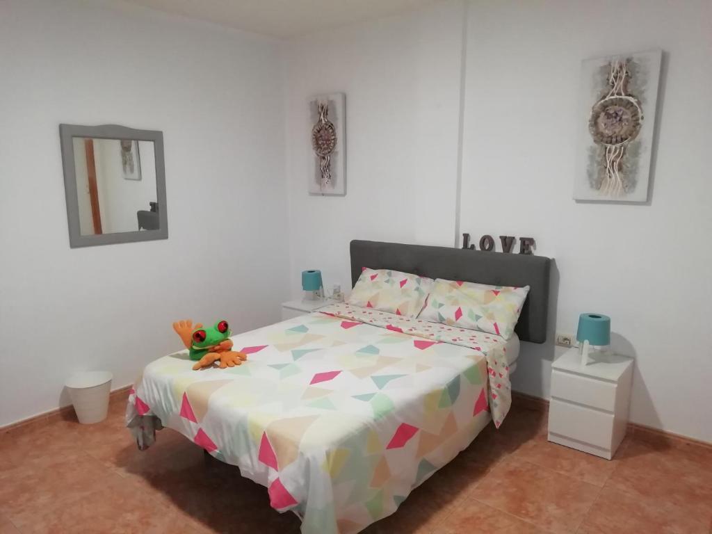 ein Schlafzimmer mit einem Bett mit einem Teddybär drauf in der Unterkunft THREE BEDROOM APARTAMENT NEAR SANTA CRUz 1A in Santa Cruz de Tenerife