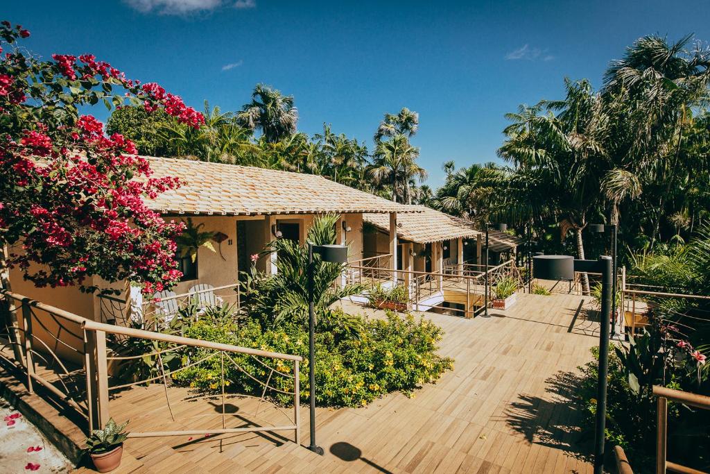 a house with a wooden deck with flowers and trees at Pousada Boa Vista in Barreirinhas