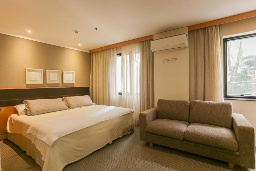 - une chambre avec un lit, un canapé et une fenêtre dans l'établissement (103)Flat Executive Jardins (Apt. particular), à São Paulo