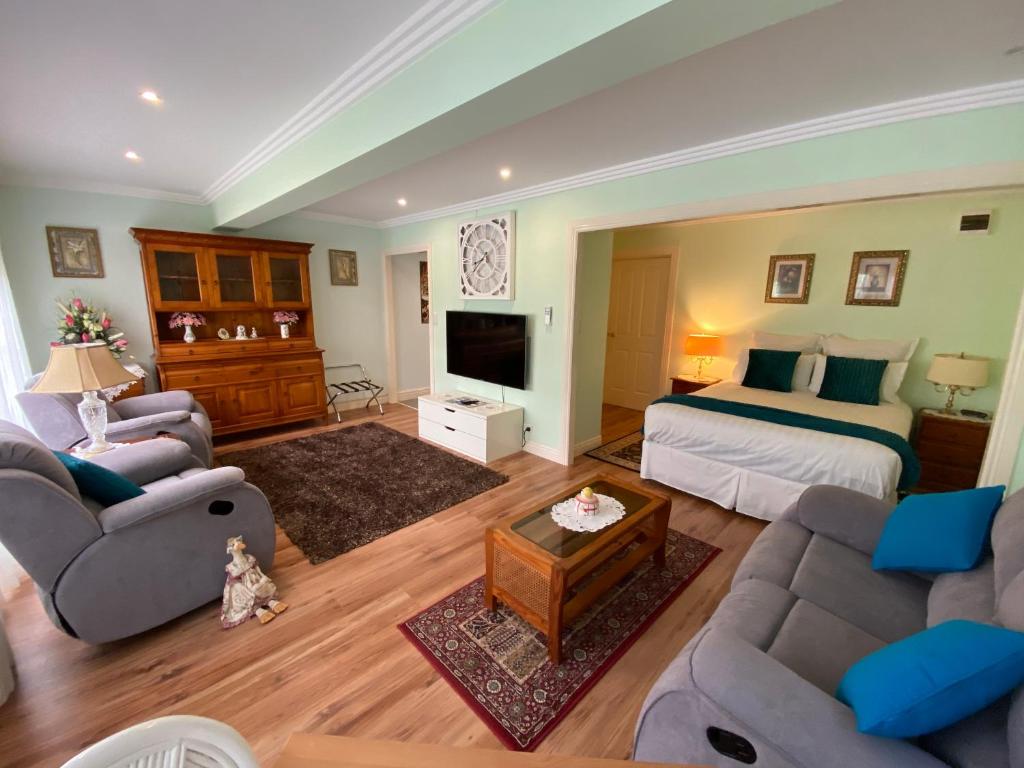 a living room with a bed and a couch and a tv at Curtis Falls Studio-Apartment in Mount Tamborine