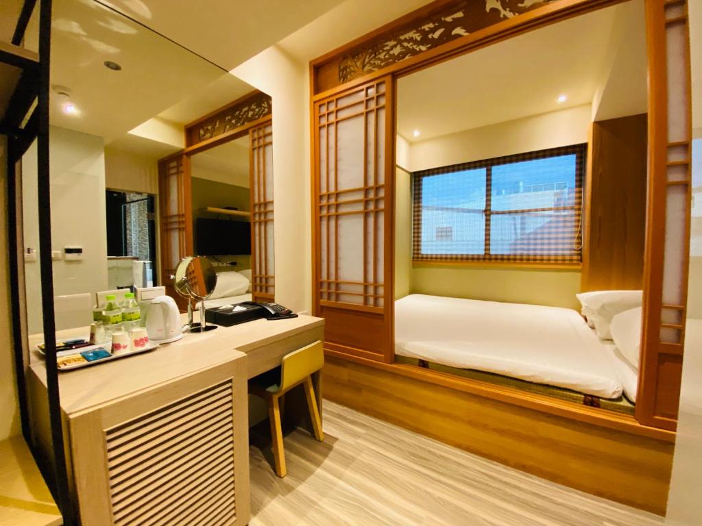 Habitación con escritorio y dormitorio con cama. en Cai Mei Hotel, en Dahu
