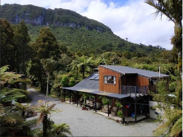 a house in the middle of a mountain at Te Nikau Retreat in Punakaiki