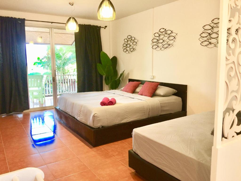een slaapkamer met 2 bedden en een raam bij Insook Ko Larn Resort in Ko Larn