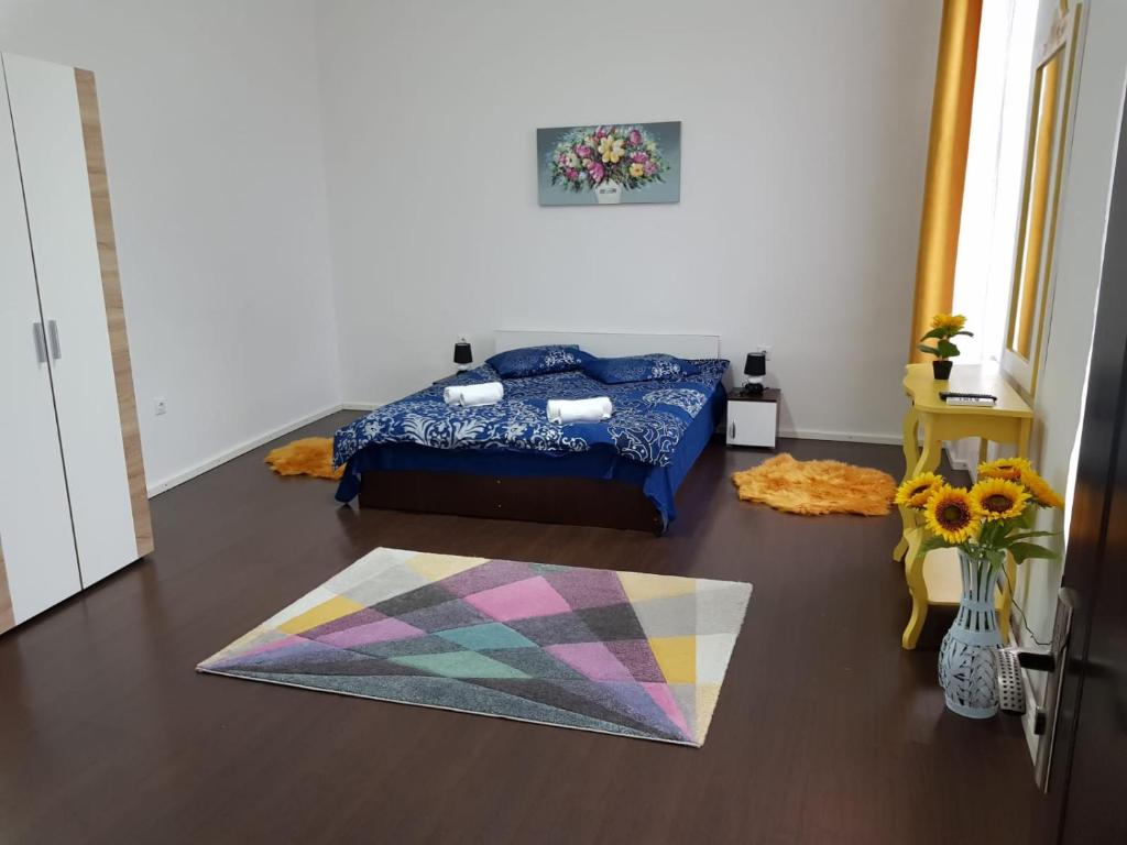 a bedroom with a bed and a rug on the floor at Apartament 12 Central in Târgu-Mureş
