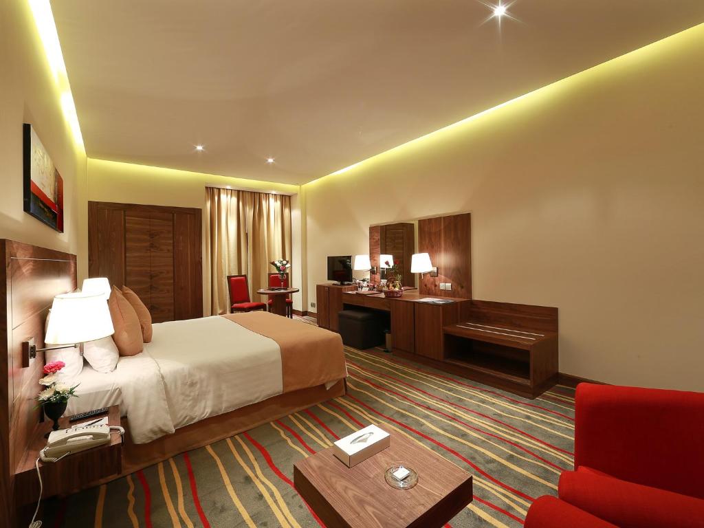 a hotel room with a bed and a desk at Al Khaleej Palace Deira Hotel in Dubai