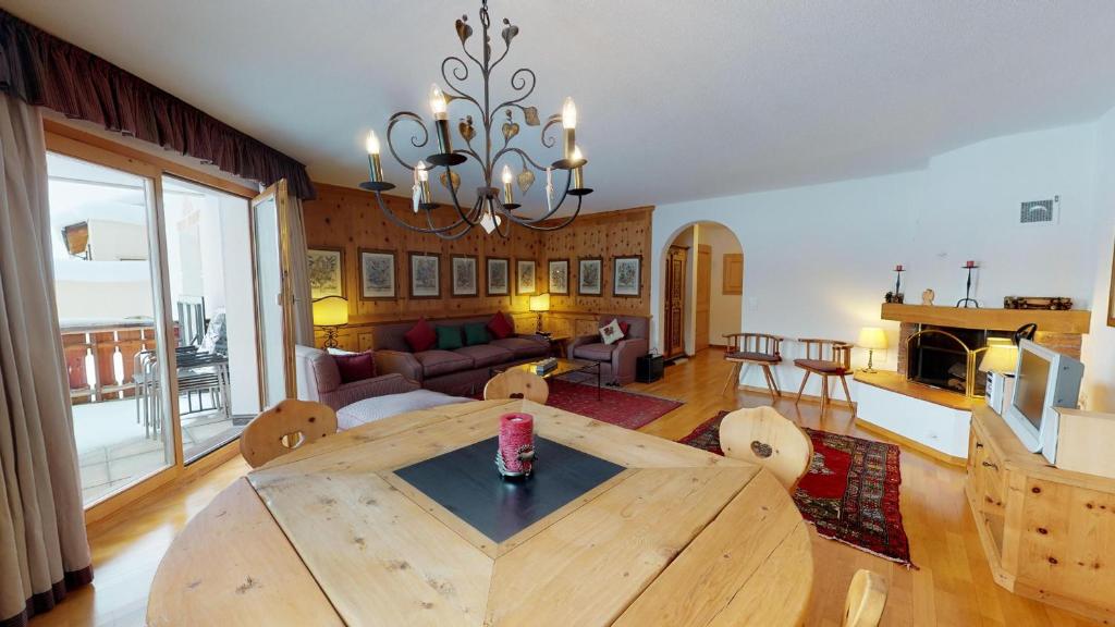 a living room with a wooden table and a dining room at Abitaziun Trais Tschiervs D5 - Champfèr in Champfer