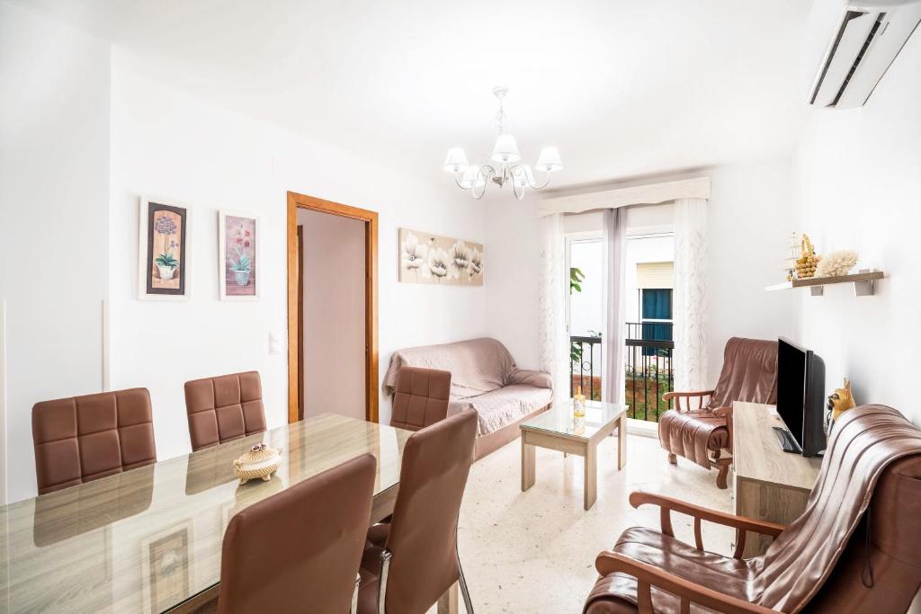 ein Esszimmer und ein Wohnzimmer mit Tisch und Stühlen in der Unterkunft Apartamento Conil Centro in Conil de la Frontera