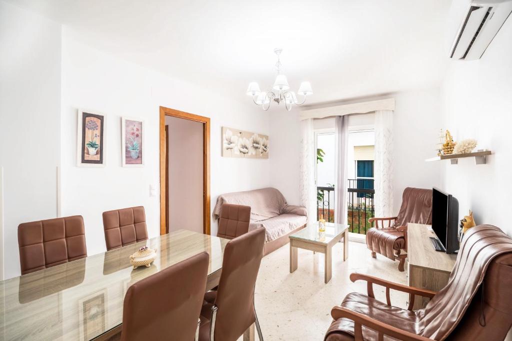 a dining room and living room with a table and chairs at Apartamento Conil Centro in Conil de la Frontera