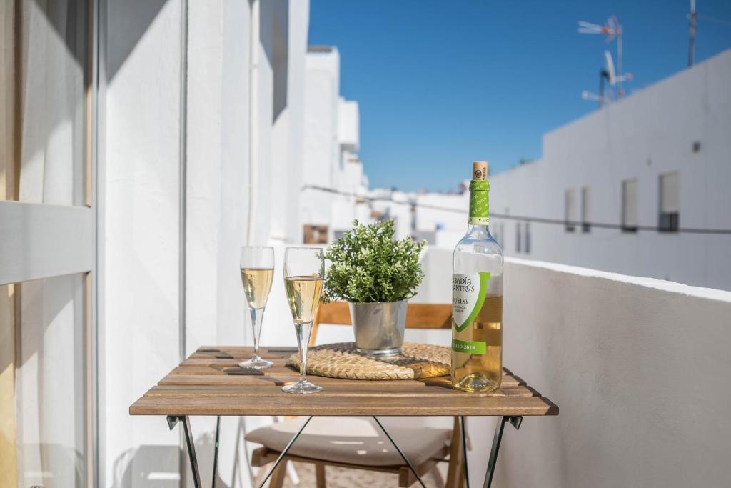 - une table avec 2 verres et une bouteille de champagne dans l'établissement Piso Carmen Solo Familias, à Conil de la Frontera