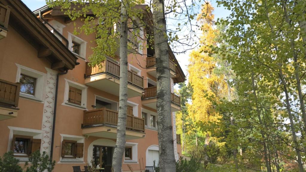 un edificio con balcones y árboles delante de él en Aruons en St. Moritz