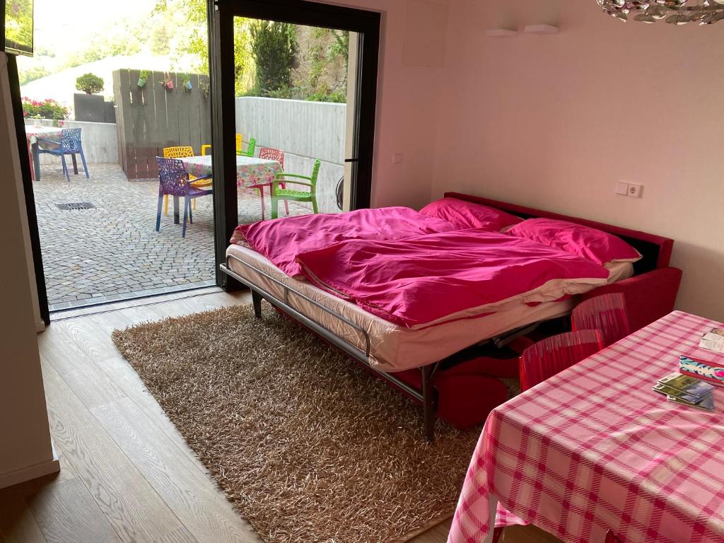 菲耶的住宿－Casa Sciliar centro paese，一间卧室配有一张床铺,床上铺有粉色毯子