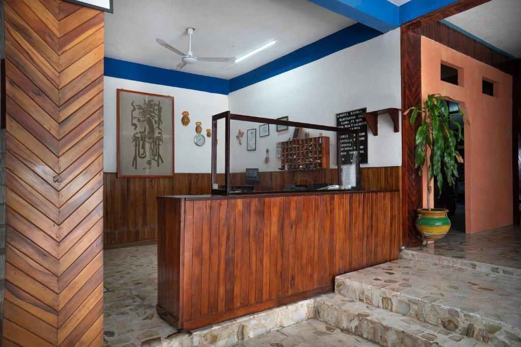 un restaurante en el vestíbulo con una barra y una planta en Hotel Kashlan Palenque en Palenque