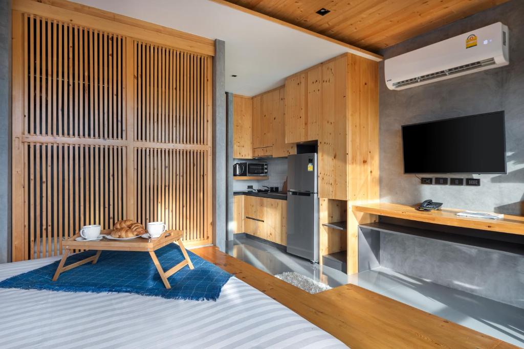 um quarto com uma cama e uma mesa com uma televisão em Relife The Windy by VillaCarte em Praia de Rawai