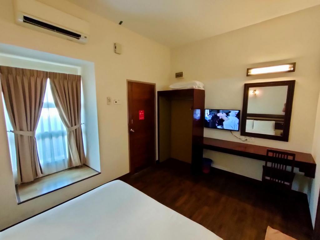 Postel nebo postele na pokoji v ubytování Cozzy Motel Malacca