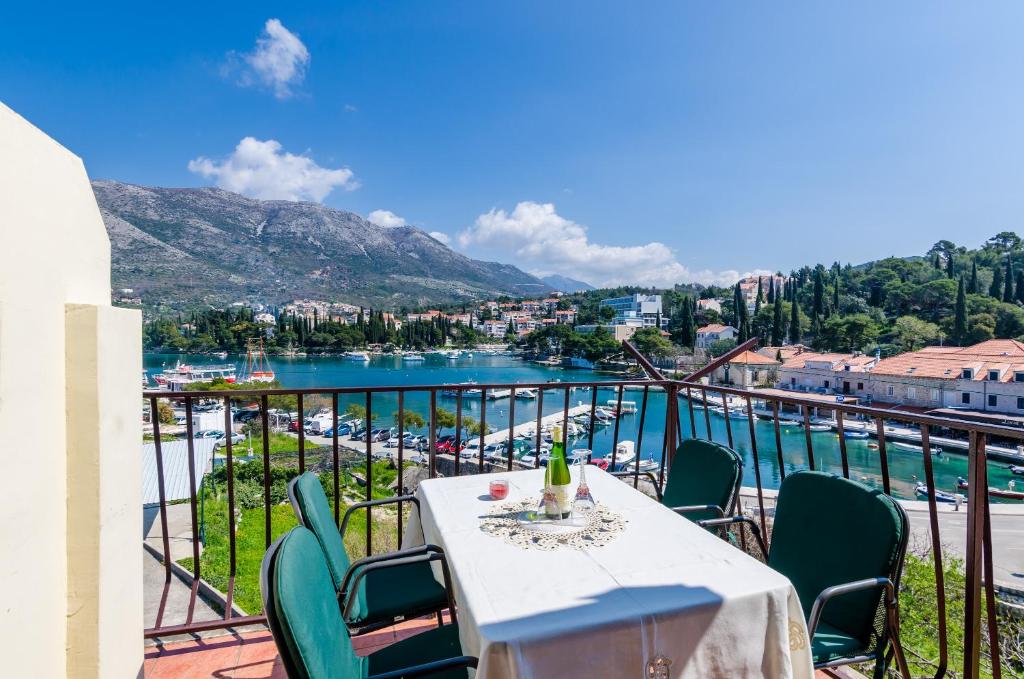 einen Tisch und Stühle auf einem Balkon mit Flussblick in der Unterkunft Apartments & Rooms Mihajica in Cavtat