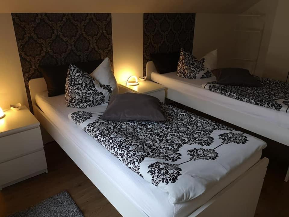 two twin beds in a room with two lamps at Haus am Hang; Ferienwohnung Fernblick in Stolberg