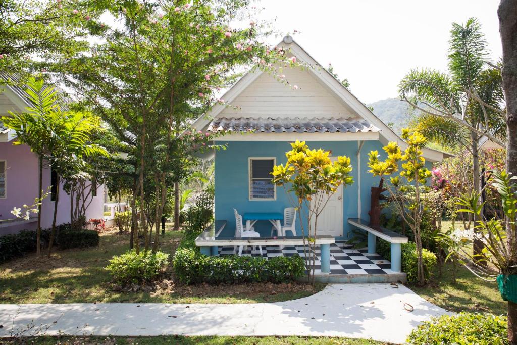 une maison bleue et blanche avec une terrasse couverte dans l'établissement Baanraisooksangchan, à Kaeng Krachan