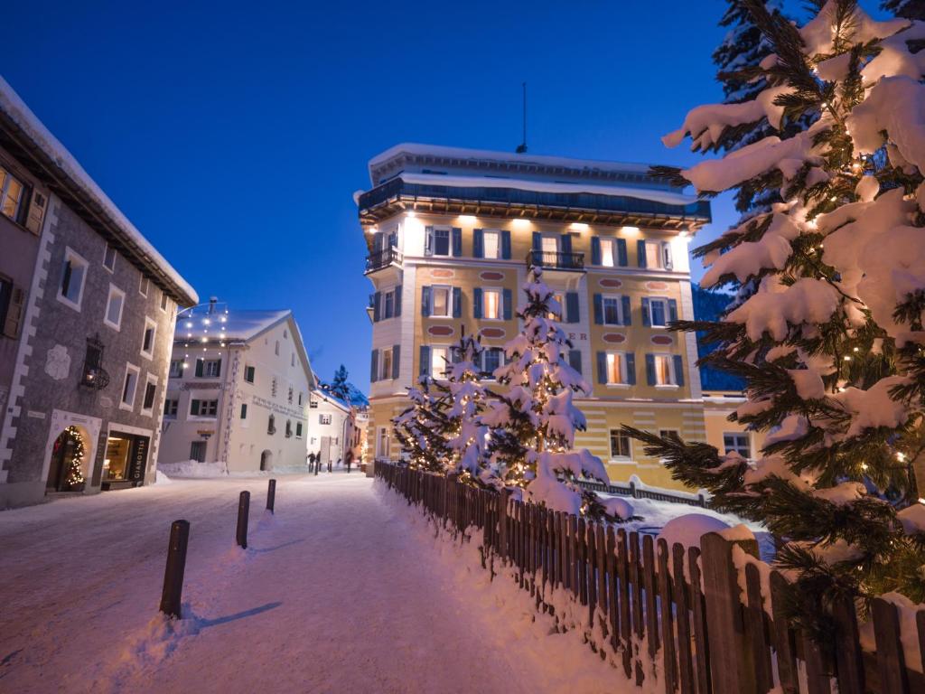 a building with a christmas tree in front of it at Hotel Müller - mountain lodge in Pontresina