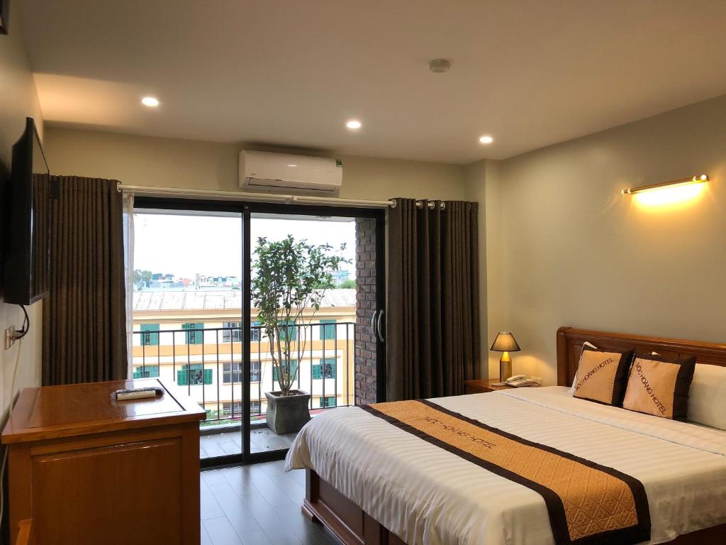 1 dormitorio con cama y ventana grande en Moc Hoang Hotel en Hanói