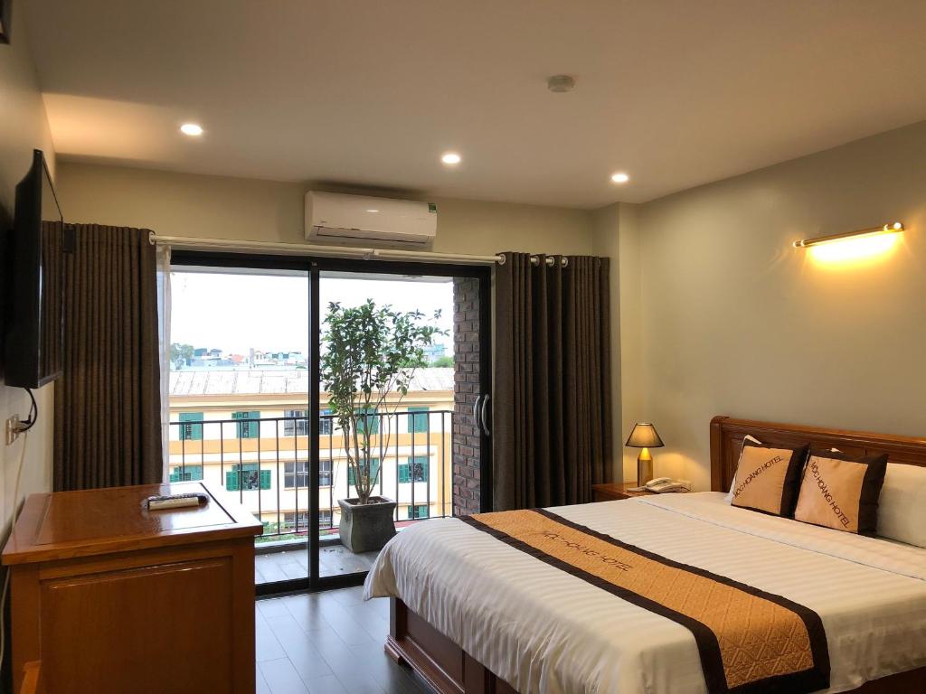 a bedroom with a bed and a large window at Moc Hoang Hotel in Hanoi