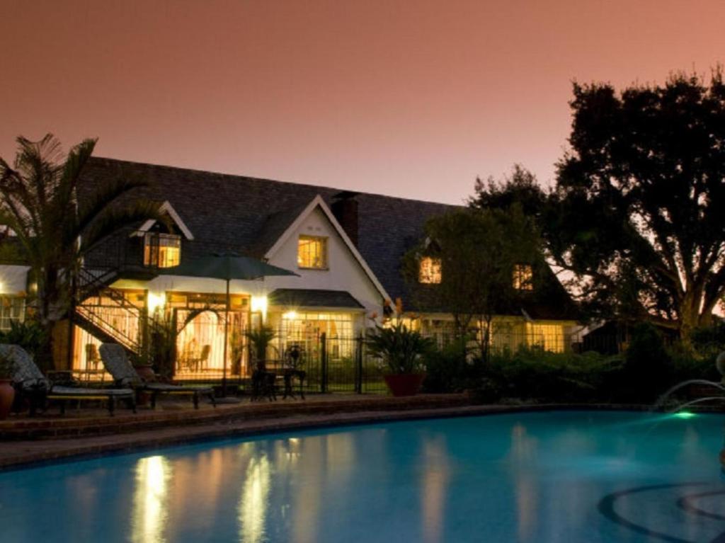 a house with a swimming pool at night at Gallo Manor Executive Bed & Breakfast in Johannesburg