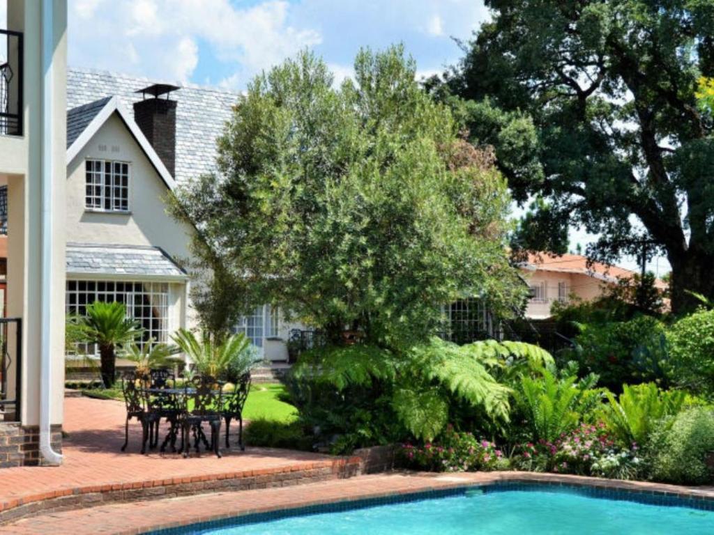 a swimming pool in front of a house at Gallo Manor Executive Bed & Breakfast in Johannesburg