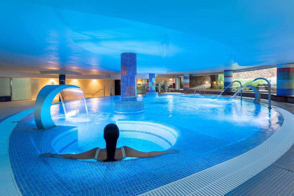 a person in a swimming pool at a hotel at MUR Faro Jandia Fuerteventura & Spa in Morro del Jable