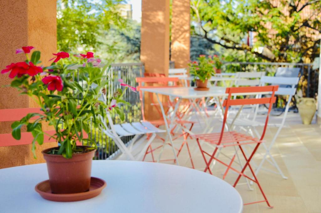 a white table with red flowers on a patio at Casa Lighea Mondello - 200 mt dalla spiaggia in Mondello