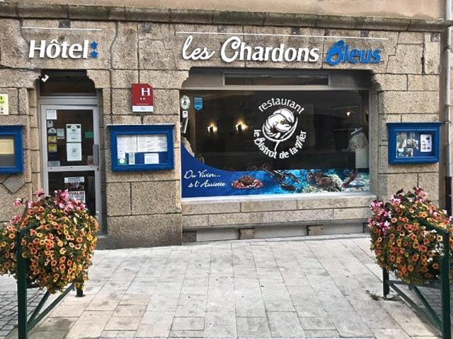 a store front of a hotel with flowers in front of it at Logis Hôtel Les Chardons Bleus RESTAURANT LE BISTROT DE LA MER in Roscoff