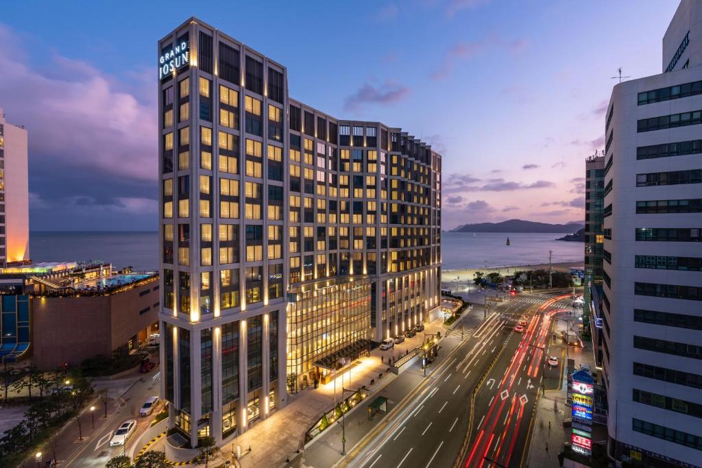 a tall building on a city street at night at Grand Josun Busan in Busan