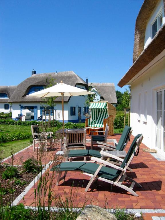 a group of chairs and an umbrella on a patio at Ferienhaus Windrose in Breege
