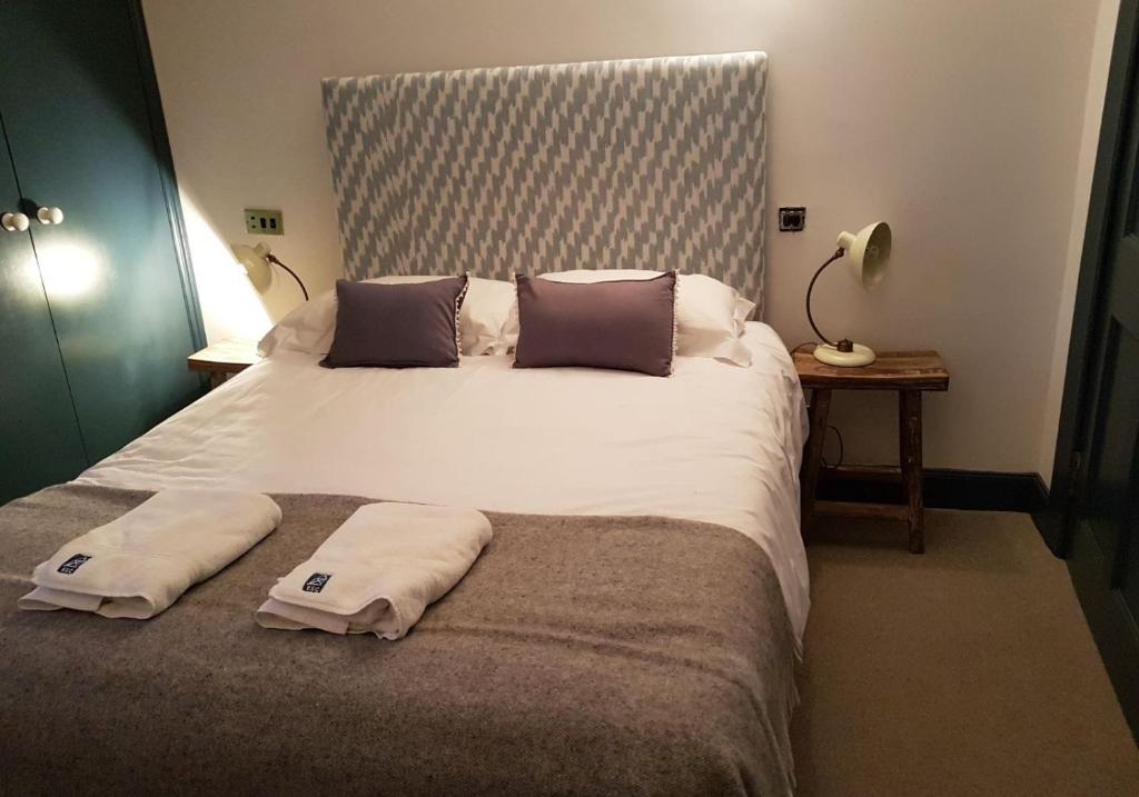 Thistle Suite city centre في إدنبرة: غرفة نوم بسرير كبير عليها مناشف