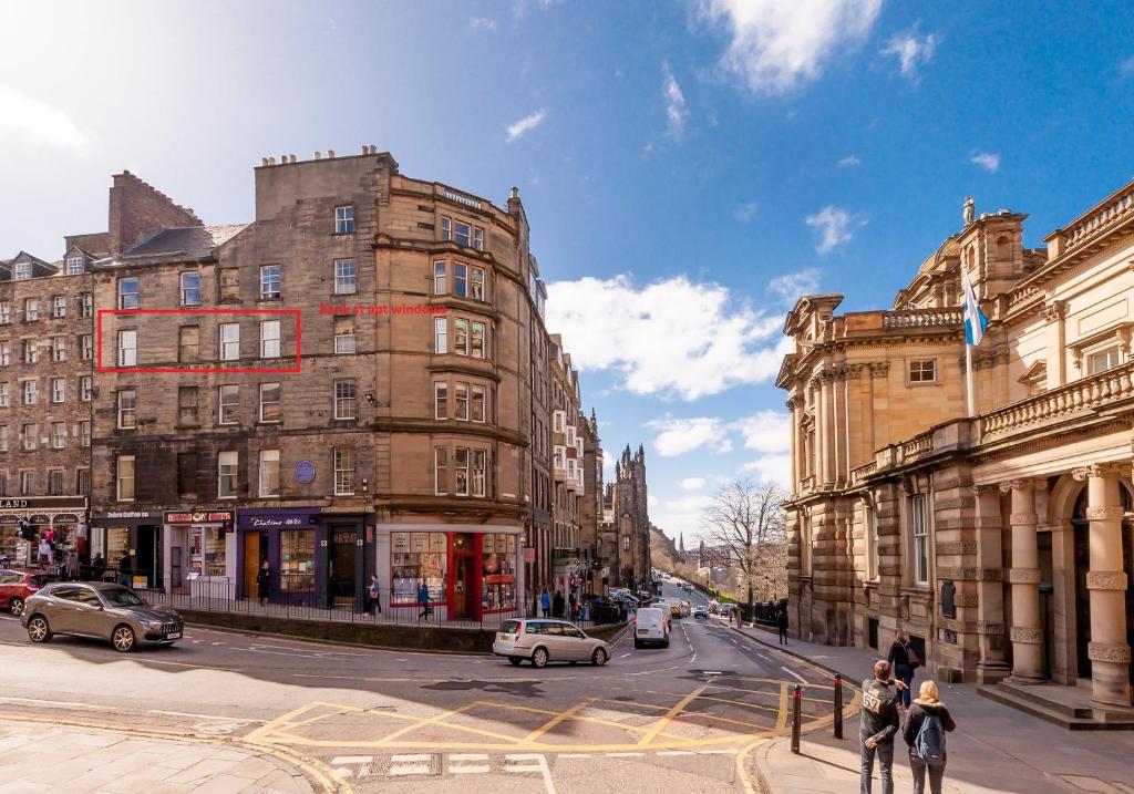 Bank St Royal Mile في إدنبرة: شارع المدينة مزدحم بالمباني والسيارات على الطريق