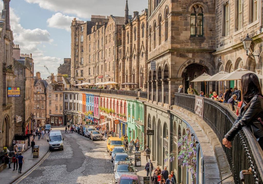 una calle de la ciudad con coches y personas caminando por un puente en West Bow just off Royal Mile, en Edimburgo