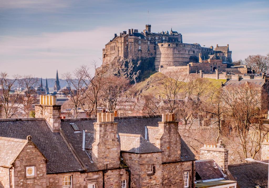 エディンバラにあるCandlemaker Old Town 500m from Edinburgh Castleの家屋が並ぶ丘の上の城