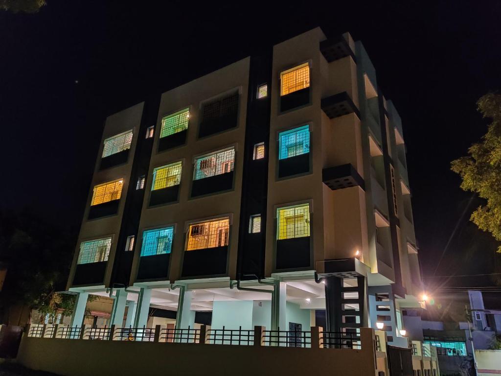 een gebouw met 's nachts verlichte ramen bij Coral Shelters Mattuthavani in Madurai