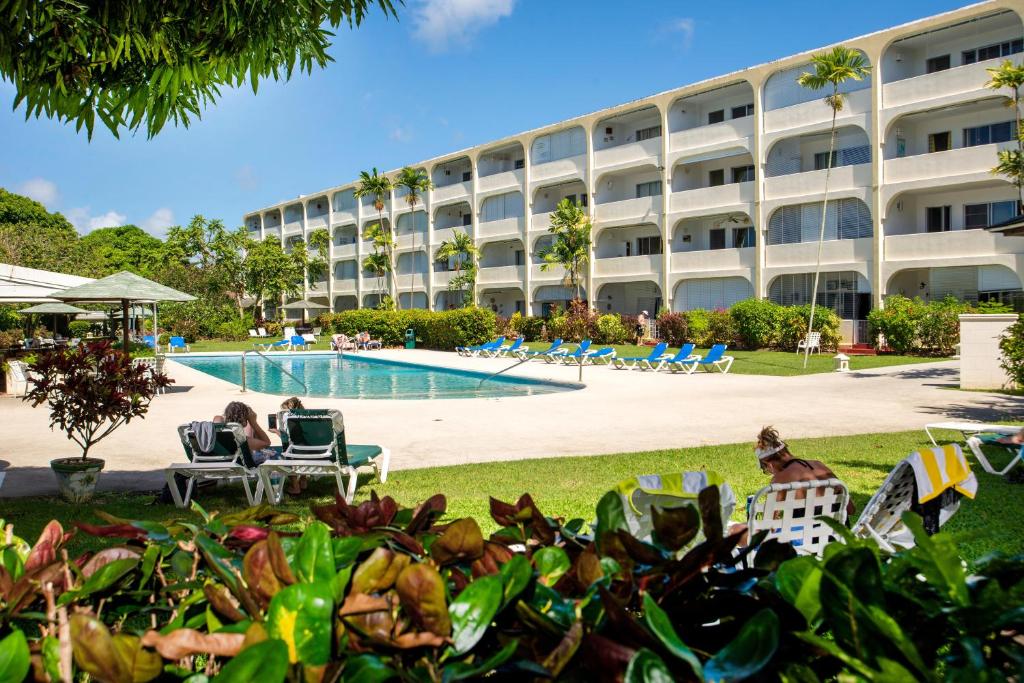 a resort with a pool and people sitting in lawn chairs at ZenBreak Golden View #115 in Saint James