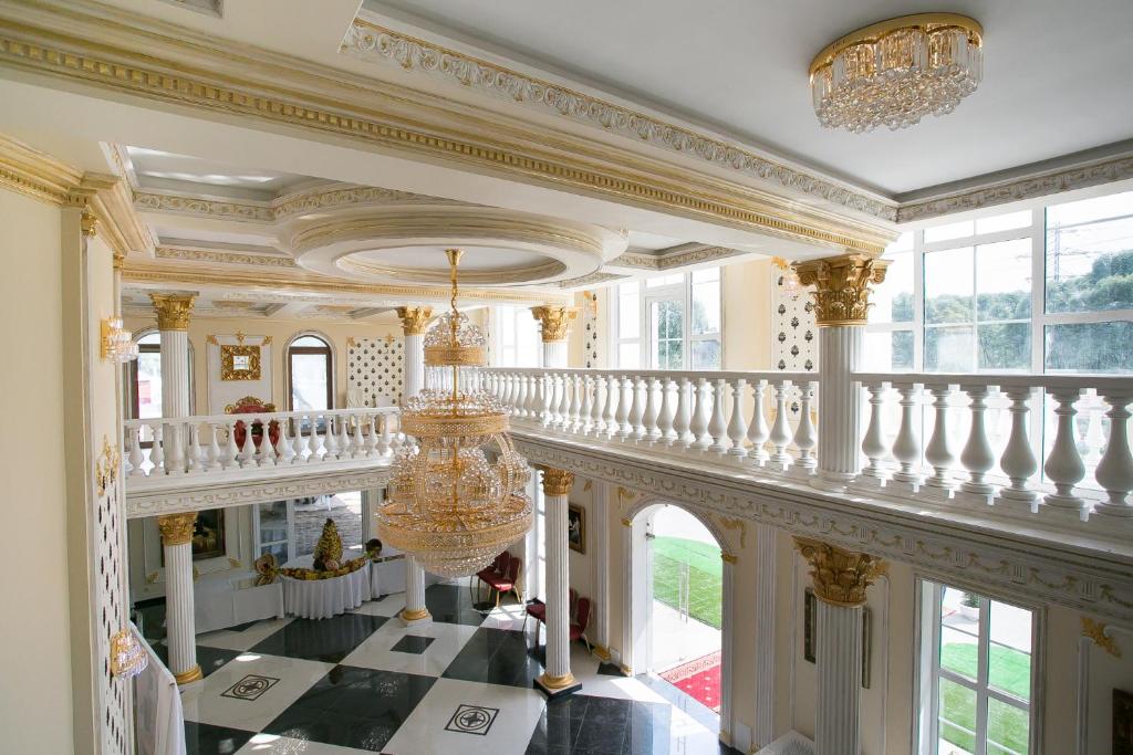 KartmazovoにあるDouble Tea Vnukovoのシャンデリア付きの階段がある広い客室です。