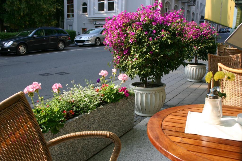 uma mesa, cadeiras e flores num passeio em Cafe Schneidewind em Bad Pyrmont