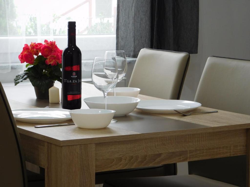 Apartments Mateo في زغرب: طاولة مع زجاجة من النبيذ وكأس