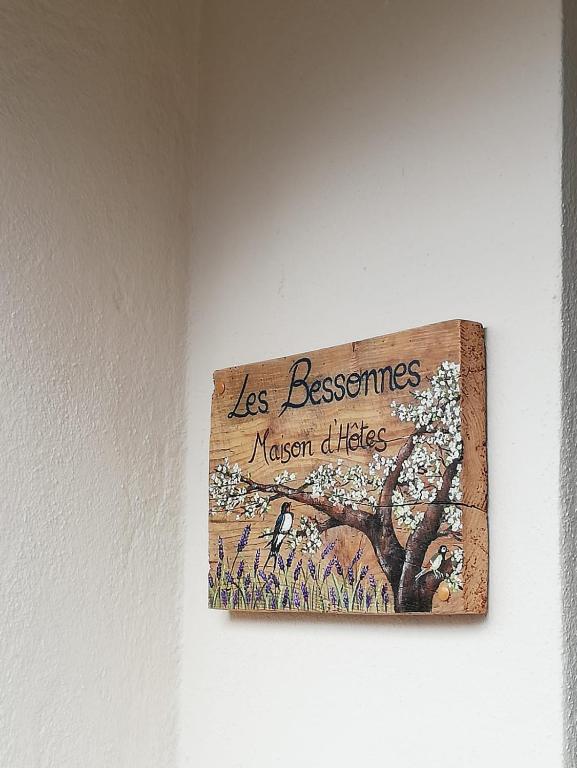 a sign on a wall with a picture of a tree at Les Bessonnes in Saint-Georges-Haute-Ville