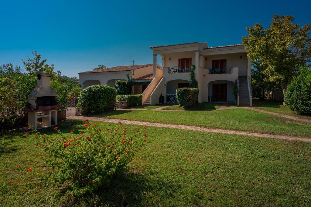 una casa grande con un patio con flores en Le Dimore di Budoni, en Budoni